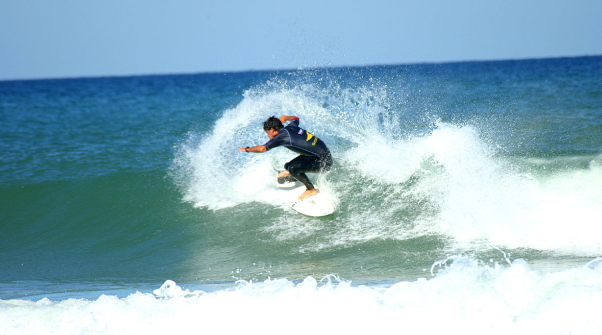 Male surfer riding a crashing wave on Lacanau beach